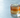 a large clear block of ice sitting nearly invisible inside the glass, barely distinguishable from the liquid around it, a single freeze-dried lime wheel resting flat on the surface undisturbed
